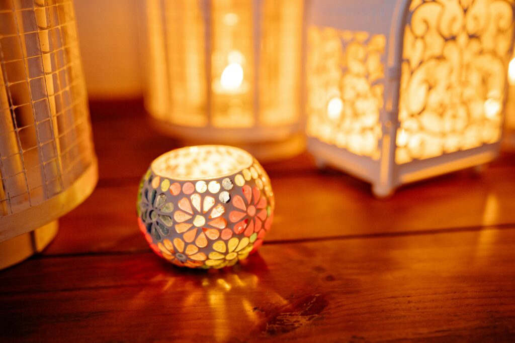 A close-up of decorative candlelit lanterns on a wooden surface, creating a cozy atmosphere.